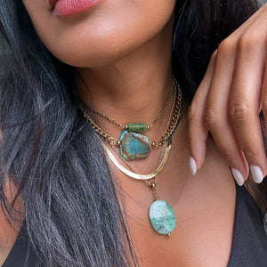 Woman wearing green blue crystal necklaces