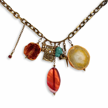 Gold chain necklace featuring multiple gold and stone charms, including large yellow, orange and pink agate crystals and a turquoise bead.